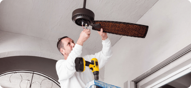 worker installing ceiling fan